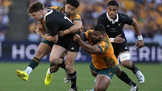 New Zealand's Jordie Barrett, left, is tackled by Australia's Hunter Paisami, second left, and Taniela Tupou during their rugby union test match in Sydney, Saturday, Sept. 21, 2024. (AP Photo/Rick Rycroft)