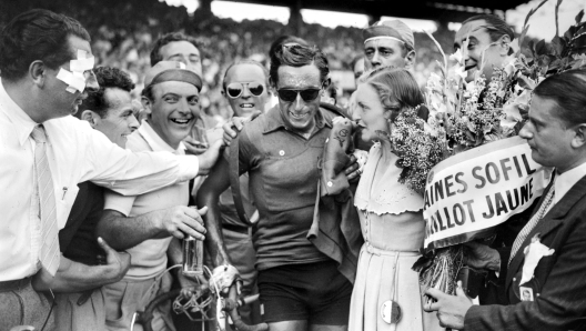 (FILES) Italian Fausto Coppi (C) is congratulated upon his arrival at the Parc des princes in Paris, after winning the Tour de France, on July 24, 1949. Gino Bartali, Fausto Coppi, Marco Pantani... the start of the Tour de France on Saturday in Florence and the three and a half stages in Italy will be an opportunity to celebrate several legends of Italian cycling, whose lives are romantic, and whose destinies are often tragic. (Photo by STAFF / AFP)