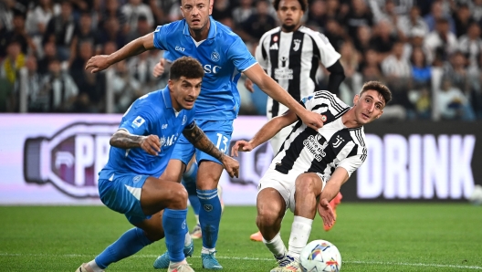 Juventus' Italian defender #27 Andrea Cambiaso (R) fights for the ball with Napoli's Kosovan defender #13 Amir Rrahmani (C) and Napoli's Italian defender #22 Giovanni Di Lorenzo (L)  during the Italian Serie A football match Juventus vs Napoli at the Juventus Stadium in Turin on September 21, 2024. (Photo by Isabella BONOTTO / AFP)