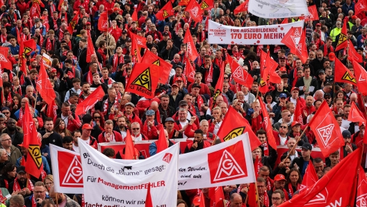 Members of the IG Metall metalworkers union demonstrate on September 25, 2024 in Hanover, northern Germany, where talks between unions and the Volkswagen management are taking place following an announcement of German carmaker Volkswagen (VW) that drastic cost-cutting measures are needed to keep the carmaker competitive. After Volkswagen's bombshell announcement earlier in September 2024 that it could close factories in Germany for the first time, company management and unions will begin tense talks on a new pay deal. Volkswagen has repeatedly stressed that its costs are excessive and profit margins too low, particularly at its core VW brand. (Photo by RONNY HARTMANN / AFP)