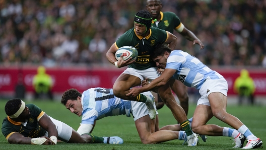 South Africa's Kurt-Lee Arendse, center, is tackled by Argentina's Santiago Carreras during a rugby championship test match at Mbombela stadium in Nelspruit, South Africa, Saturday, Sept. 28, 2024. (AP Photo/Themba Hadebe)