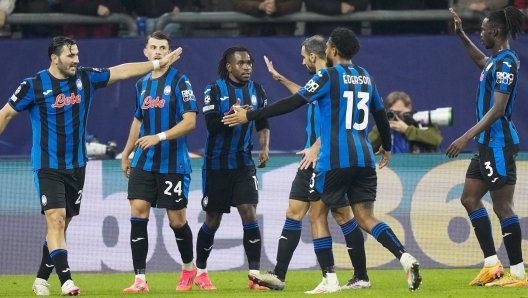 Atalanta's Ademola Lookman celebrates with his teammates after scoring his side's second goal during the Champions League opening phase soccer match between Shakhtar Donetsk and Atalanta at the Arena AufSchalke in Gelsenkirchen, Germany, Wednesday Oct. 2, 2024. (AP Photo/Martin Meissner)