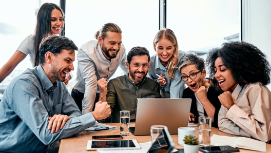 Business success. Excited multinational entrepreneurs making winner gesture while celebrating achieving impressive target. Lucky investor making profitable deal with promising international partner.