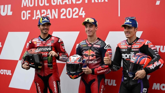 MogoGP class pole sitter Red Bull GASGAS Tech3 rider Pedro Acosta of Spain (C) poses with Ducati Lenovo Team rider Francesco Bagnaia of Italy (L) and Aprilia Racing rider Maverick Vinales of Spain (R) at the parc ferme after the qualifying session of MotoGP Japanese Grand Prix at the Mobility Resort Motegi in Motegi, Tochigi prefecture on October 5, 2024. (Photo by Toshifumi KITAMURA / AFP)