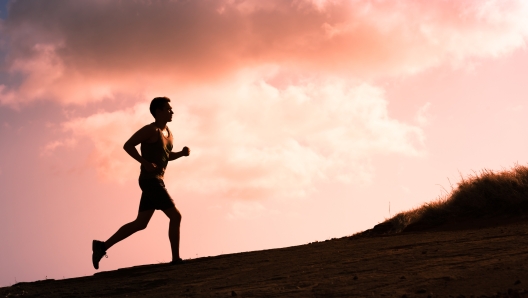 Fitness male running outdoors during sunset. Healthy lifestyle concept.