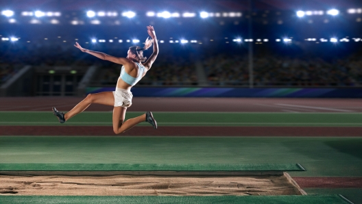 Long Jump Championship: Professional Female Athlete Jumping on Long Distance. Determination, Motivation, Inspiration of a Successful Sports Woman Setting New Record Result. Competition on Big Stadium.