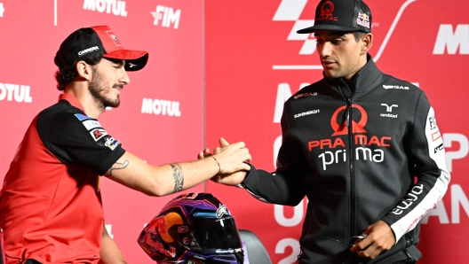 Ducati Lenovo Team rider Francesco Bagnaia of Italy (L) shakes hands with Prima Pramac Racing rider Jorge Martin of Spain (R) during the press conference for October 6 MotoGP Japanese Grand Prix at the Mobility Resort Motegi in Motegi, Tochigi prefecture on October 3, 2024. (Photo by Toshifumi KITAMURA / AFP)