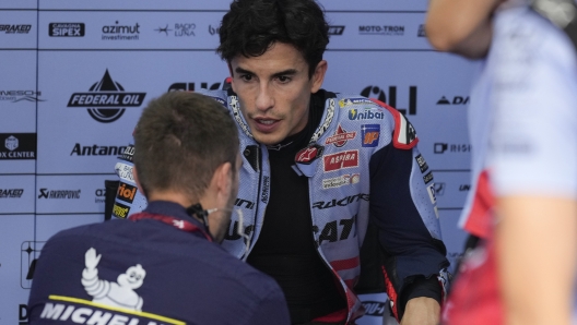 Spanish rider Marc Marquez of Gresini Racing MotoGP talks to team mechanic at garage at the Twin Ring Motegi circuit in Motegi, north of Tokyo, Japan, Sunday, Oct. 6, 2024, ahead of MotoGP Japanese Motorcycle Grand Prix. (AP Photo/Hiro Komae)