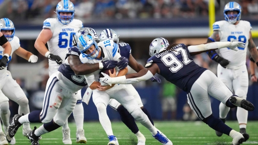 ARLINGTON, TEXAS - OCTOBER 13: Jared Goff #16 of the Detroit Lions is sacked by Mazi Smith #58 and Osa Odighizuwa #97 of the Dallas Cowboys in the second quarter of a game at AT&T Stadium on October 13, 2024 in Arlington, Texas.   Sam Hodde/Getty Images/AFP (Photo by Sam Hodde / GETTY IMAGES NORTH AMERICA / Getty Images via AFP)