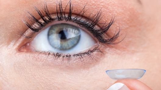 Woman eye with contact lens applying, macro