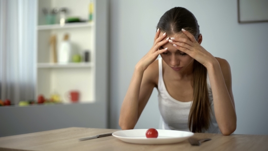 Anorexic girl feels dizzy, depleted by severe diets, exhausted body, starvation