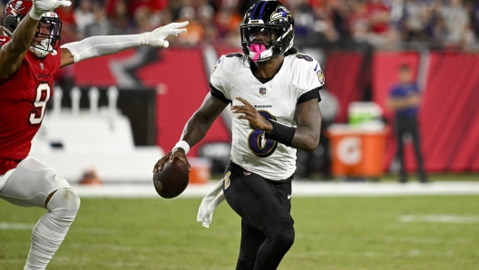 Baltimore Ravens quarterback Lamar Jackson is pressured by Tampa Bay Buccaneers linebacker Joe Tryon-Shoyinka (9) during the first half of an NFL football game, Monday, Oct. 21, 2024, in Tampa, Fla. (AP Photo/Jason Behnken)