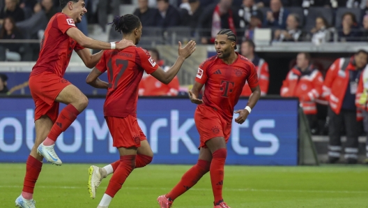 epa11646074 Michael Olise of Munich (C) celebrates with teammate Serge Gnabry (R) after scoring the 2-3 during the German Bundesliga soccer match between Eintracht Frankfurt and FC Bayern Munich in Frankfurt, Germany, 06 October 2024.  EPA/CHRISTOPHER NEUNDORF CONDITIONS - ATTENTION: The DFL regulations prohibit any use of photographs as image sequences and/or quasi-video.