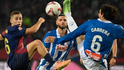 Barcelona's Spanish midfielder #16 Fermin Lopez (L) is challenged by  Espanyol's Uruguayan defender #06 Leandro Cabrera during the Spanish league football match between FC Barcelona and RCD Espanyol at the Estadi Olimpic Lluis Companys in Barcelona, on November 3, 2024. (Photo by Josep LAGO / AFP)