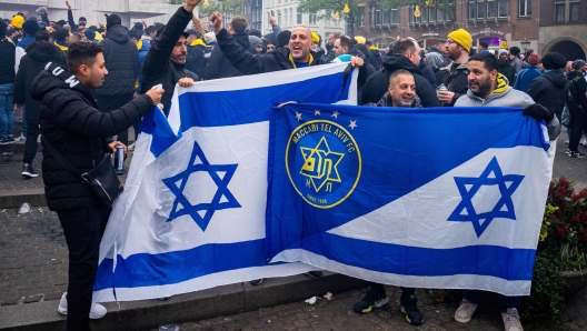 Supporters of Maccabi Tel Aviv hold flags at Dam square ahead of the Europa League football match between Ajax and Maccabi Tel Aviv, in Amsterdam on November 7, 2024. (Photo by Jeroen Jumelet / ANP / AFP) / Netherlands OUT