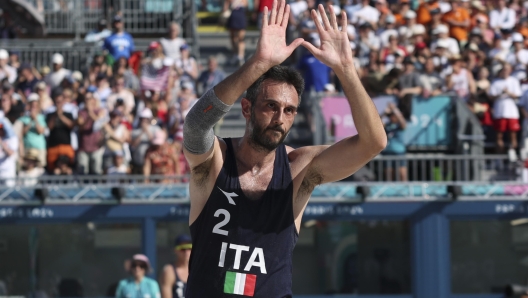 epa11528228 Paolo Nicolai of Italy waves to the crowd after losing in the Men round of 16 match between USA and Italy in the Beach Volleyball competitions in the Paris 2024 Olympic Games, at the Eiffel Tower in Paris, France, 05 August 2024.  EPA/RITCHIE B. TONGO