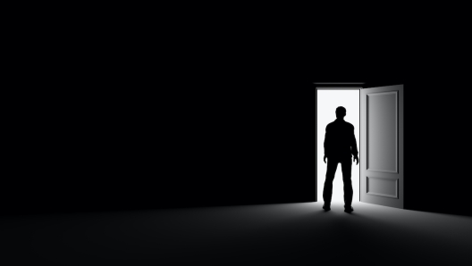 Silhouette of a man standing in a dark room lit by bright light. 3d rendering