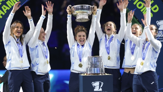 TOPSHOT - Italy's Jasmine Paolini (C) and Team Italy teammates hold up the trophy after winning the Billie Jean King Cup Finals at the Palacio de Deportes Jose Maria Martin Carpena arena in Malaga, southern Spain, on November 20, 2024. (Photo by Thomas COEX / AFP)