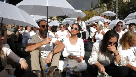 epaselect epa11730968 Rachel and Jon Goldberg-Polin, the parents of an Israeli-American hostage ersh Goldberg-Polin killed in captivity, join hundreds of women dressed in white with umbrellas; mothers, sisters and family members of Israeli hostages held in by Hamas in Gaza,  block a road outside Prime Minister Benjamin Netanyahu's residence during a quiet protest calling for the release of hostages, in Jerusalem, 20 November 2024. According to the Israeli army (IDF) spokesperson, around 100 Israeli hostages remain in captivity in the Gaza Strip, including the bodies of 33 confirmed dead.  EPA/ABIR SULTAN