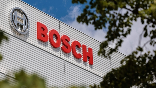 (FILES) In this file photo taken on July 12, 2022 the logo of German manufacturer Bosch is pictured on the facade of the semiconductor factory's main building in Dresden, eastern Germany. Germany's Bosch said on November 22, 2024 it planned to cut thousands of jobs in its automotive businesses as car suppliers struggle to manage the difficult transition from combustion engines to electric vehicles. Some 5,500 jobs would be axed worldwide, with the majority in Germany, according to figures provided by the company. (Photo by JENS SCHLUETER / AFP)