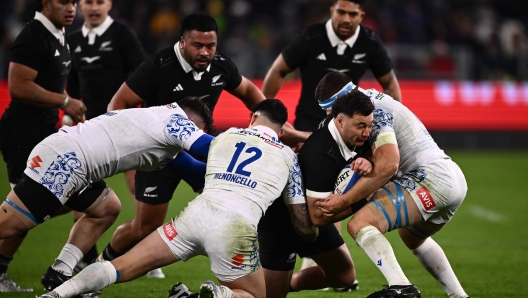 New-Zealand's wing Rieko Ioane (R) protects the ball during the Autumn Nations Series International rugby union test match between Italy and New Zealand at the Allianz Stadium in Turin, on November 23, 2024. (Photo by MARCO BERTORELLO / AFP)