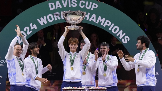 Italy's Jannik Sinner, center, holds the Davis Cup trophy by teammates after the final between Netherlands and Italy at the Martin Carpena Sports Hall in Malaga, southern Spain, as Italy wins its second consecutive Davis Cup title, Sunday, Nov. 24, 2024. (AP Photo/Manu Fernandez)