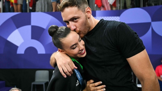 Massimo Bertelloni proposes to Italy's Alessia Maurelli after she competed in the rhytmic gymnastics' group all-around final during the Paris 2024 Olympic Games at the Porte de la Chapelle Arena in Paris, on August 10, 2024. (Photo by Gabriel BOUYS / AFP)