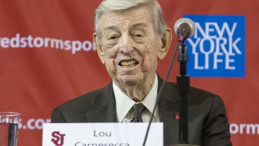 FILE - Former St. John's men's basketball coach Lou Carnesecca smiles during a news conference to announce the hiring of his former player and retired NBA basketball All-Star Chris Mullin, on April 1, 2015, in New York. (AP Photo/John Minchillo, File)