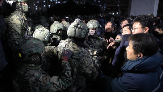 SEOUL, SOUTH KOREA - DECEMBER 03: South Korean soldiers try get into the national assembly on December 03, 2024 in Seoul, South Korea. South Korean lawmakers voted to lift the declaration of emergency martial law announced earlier by President Yoon Suk Yeol in a televised speech. Since taking office two years ago, Mr Yoon has struggled to push his agendas against an opposition-controlled parliament. (Photo by Chung Sung-Jun/Getty Images)