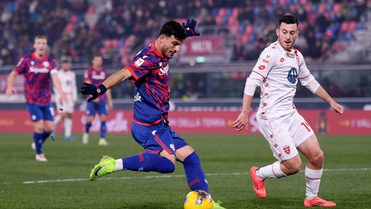 BOLOGNA, ITALY - DECEMBER 03: Riccardo Orsolini of Bologna takes a shot whilst under pressure from Samuele Birindelli of AC Monza during the Coppa Italia match between Bologna FC and AC Monza at Renato Dall'Ara Stadium on December 03, 2024 in Bologna, Italy. (Photo by Alessandro Sabattini/Getty Images)