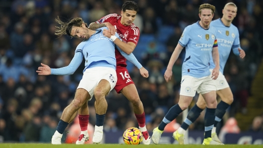 Manchester City's Erling Haaland, right, and Kevin De Bruyne, second from right, looks on as Manchester City's Jack Grealish, left, and Nottingham Forest's Nicolas Dominguez challenge for the ball during the English Premier League soccer match between Manchester City and Nottingham Forest at the Etihad Stadium in Manchester, Wednesday, Dec. 4, 2024. (AP Photo/Dave Thompson)