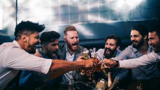 Group of young men toasting with beer at a nightclub