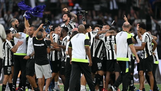 Botafogo players celebrate after winning the championship during the Brasileirao Seria A football match between Botafogo and Sao Paulo at the Nilton Santos Olympic stadium in Rio de Janeiro, Brazil, on December 8, 2024. (Photo by Mauro PIMENTEL / AFP)