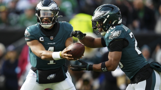 Philadelphia Eagles quarterback Jalen Hurts (1) hands off to Philadelphia Eagles running back Saquon Barkley (26) during the first half of an NFL football game against the Carolina Panthers on Sunday, Dec. 8, 2024, in Philadelphia. (AP Photo/Derik Hamilton)