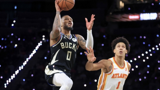 Milwaukee Bucks guard Damian Lillard (0) shoots against Atlanta Hawks forward Jalen Johnson (1) during the second half of a semifinal game in the NBA Cup basketball tournament Saturday, Dec. 14, 2024, in Las Vegas. (AP Photo/Ian Maule)