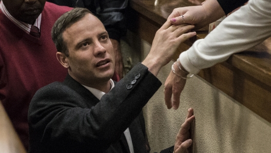 FILE ? Oscar Pistorius leaves the High Court in Pretoria, South Africa, Wednesday, July 6, 2016 after a judge passed a new sentence of six years imprisonment after his conviction was changed to murder for shooting girlfriend Reeva Steenkamp in 2013. Pistorius shot his girlfriend Reeva Steenkamp more than a decade ago in a Valentine's Day, killing that jolted the world and shattered the image of a sports superstar. (Marco Longari, Pool Photo via AP/File)