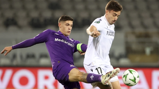 Fiorentina's Lucas Martinez Quarta vies for the ball with Vitoria's Joao Saraiva, right, during the Europa Conference League opening phase soccer match between Vitoria SC and Fiorentina at the D. Afonso Henriques stadium in Guimaraes, Portugal, Thursday, Dec. 19, 2024. (AP Photo/Luis Vieira)