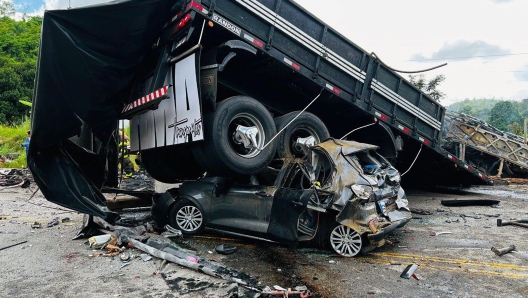 Handout picture released by Minas Gerais Fire Department shows a truck on top of a car on the site of a crash in Teofilo Otoni, Minas Gerais state, Brazil on December 21, 2024. An accident involving a car, a truck and a bus, killed 22 people at BR-116 highway according to a press release by Minas Gerais Fire Department. (Photo by Handout / Minas Gerais Fire Department / AFP) / RESTRICTED TO EDITORIAL USE - MANDATORY CREDIT "AFP PHOTO /  Minas Gerais Fire Department / HANDOUT /  " - NO MARKETING NO ADVERTISING CAMPAIGNS - DISTRIBUTED AS A SERVICE TO CLIENTS