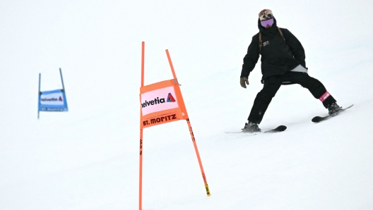 A volunteer is seen after the start of the Women's Super-G race was delayed, during the FIS Alpine ski World Cup 2024-2025, in St. Moritz on December 22, 2024. (Photo by FABRICE COFFRINI / AFP)