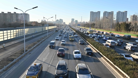 Vehicles drive in Beijing on December 23, 2024. (Photo by ADEK BERRY / AFP)