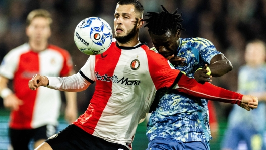 Feyenoord's Slovakian defender #33 David Hancko (L) and Ajax' Burkinabe forward #20 Bertrand Traore fight for the ball during the Dutch Eredivisie football match between Feyenoord and Ajax at Feyenoord Stadium de Kuip in Rotterdam on October 30, 2024. (Photo by Robin van Lonkhuijsen / ANP / AFP) / Netherlands OUT