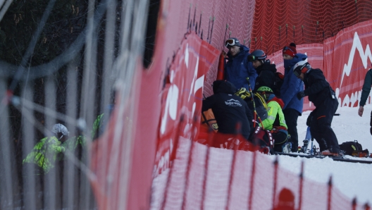 Medical staff are helping France's Cyprien Sarrazin after crashing into protections net during an alpine ski, men's World Cup downhill training, in Bormio, Italy, Friday, Dec. 27, 2024. (AP Photo/Alessandro Trovati)