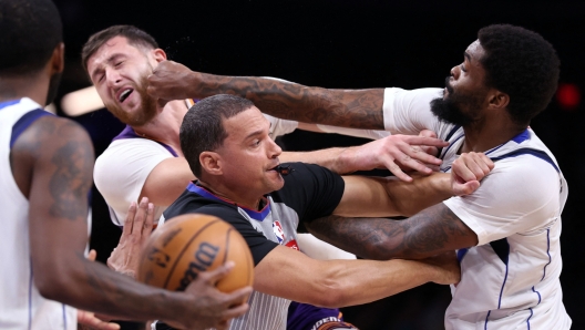 PHOENIX, ARIZONA - DECEMBER 27: Naji Marshall #13 of the Dallas Mavericks punches Jusuf Nurkic #20 of the Phoenix Suns during the second half at Footprint Center on December 27, 2024 in Phoenix, Arizona. NOTE TO USER: User expressly acknowledges and agrees that, by downloading and or using this photograph, User is consenting to the terms and conditions of the Getty Images License Agreement.   Chris Coduto/Getty Images/AFP (Photo by Chris Coduto / GETTY IMAGES NORTH AMERICA / Getty Images via AFP)