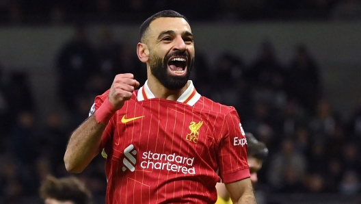 Liverpool's Egyptian striker #11 Mohamed Salah celebrates after scoring their fifth goal during the English Premier League football match between Tottenham Hotspur and Liverpool at the Tottenham Hotspur Stadium in London, on December 22, 2024. (Photo by Glyn KIRK / AFP) / RESTRICTED TO EDITORIAL USE. No use with unauthorized audio, video, data, fixture lists, club/league logos or 'live' services. Online in-match use limited to 120 images. An additional 40 images may be used in extra time. No video emulation. Social media in-match use limited to 120 images. An additional 40 images may be used in extra time. No use in betting publications, games or single club/league/player publications. /