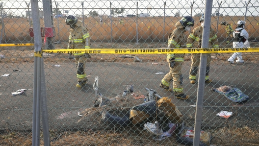 Rescue team members work near the wreckage of a passenger plane outside of Muan International Airport in Muan, South Korea, Sunday, Dec. 29, 2024. (AP Photo/Ahn Young-joon)