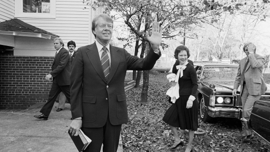 FILE - President-elect Jimmy Carter waves to the crowd as he and his wife Rosalynn arrive at the Plains Baptist Church to attend services in Plains, Ga., Nov. 22, 1976. (AP Photo, File)