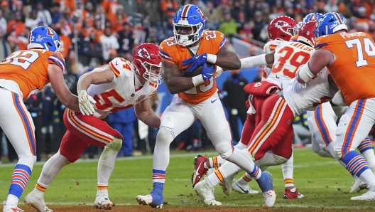 Denver Broncos running back Audric Estime (23) scores past Kansas City Chiefs linebacker Leo Chenal (54) during the second half of an NFL football game Sunday, Jan. 5, 2025, in Denver. (AP Photo/David Zalubowski)