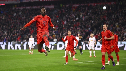 Munich's Alphonso Davies, left, celebrates his goal to make it 5:1 during the Bundesliga soccer match between Bayern Munich and RB Leipzig at the Allianz Arena, Munich, Germany, Friday Dec. 20, 2024. (Tom Welle/dpa via AP)    Associated Press / LaPresse Only italy and Spain