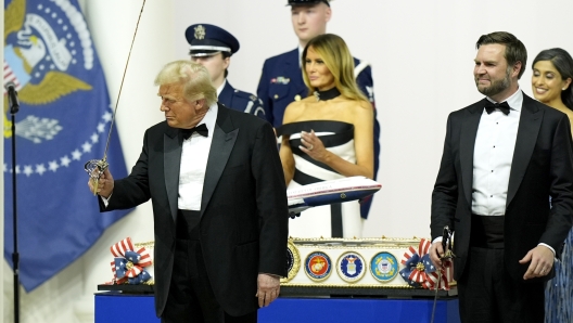 President Donald Trump, left, and Vice President JD Vance, second right, pose with sabers after using them to cut a cake as first lady Melania Trump, center, and Usha Vance, right, watch at the Commander in Chief Ball, Monday, Jan. 20, 2025, in Washington. (AP Photo/Alex Brandon)