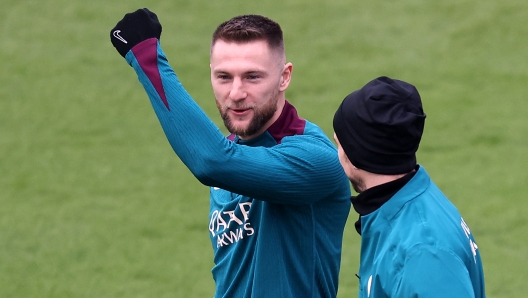 Paris Saint-Germain's Slovak defender #37 Milan Skriniar (L) speaks with Paris Saint-Germain's Spanish midfielder #08 Fabian Ruiz before a training session on the eve of the L1 football match PSG against AS Saint-Etienne in Poissy, west of Paris, on January 11, 2025. (Photo by FRANCK FIFE / AFP)